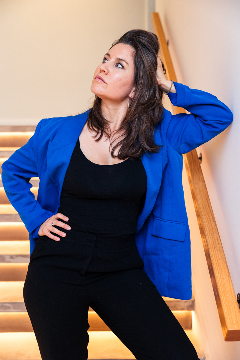 Jennifer Lacher in a blue blazer on a staircase