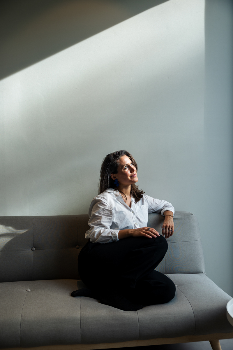 Jennifer Lacher sitting thoughtfully on a couch